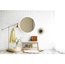 Espace d''entrée avec miroir, banc, lampadaire et décorations devant un mur de briques blanches