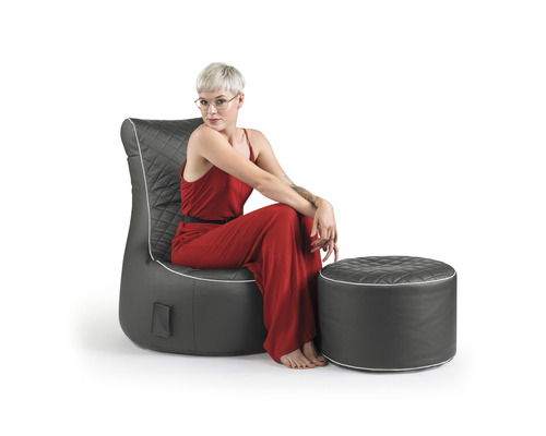 Frau sitzt in einem Sessel mit Hocker