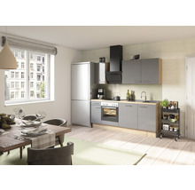 Cuisine claire avec table à manger, chaises, kitchenette avec appareils électroménagers et chariot de cuisine.