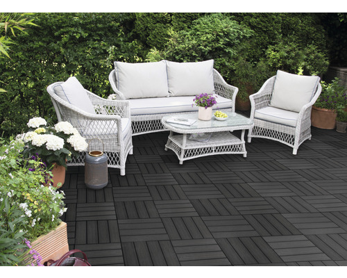 Terrasse avec des dalles de terrasse sombres et un salon de jardin en rotin