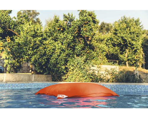 Pouf orange dans la piscine devant les arbres