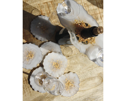 Weinset mit Flaschenhalter, Untersetzern und Gläsern auf Holztisch