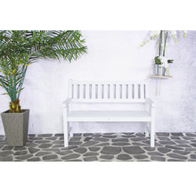 Banc de jardin blanc en bois à côté d''un palmier en pot