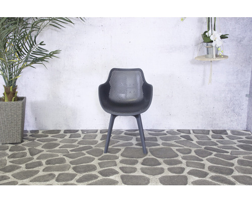 Chaise en plastique noire avec accoudoirs devant un mur