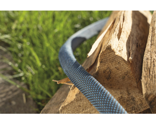 Tuyau d''arrosage flexible posé sur du bois