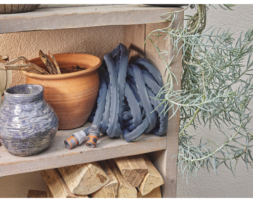 Scène de jardin avec tuyau d''arrosage, pots de fleurs et étagère en bois