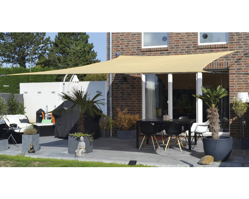 Terrasse avec voile d''ombrage, table et chaises, ainsi que des bacs à plantes pour l''extérieur