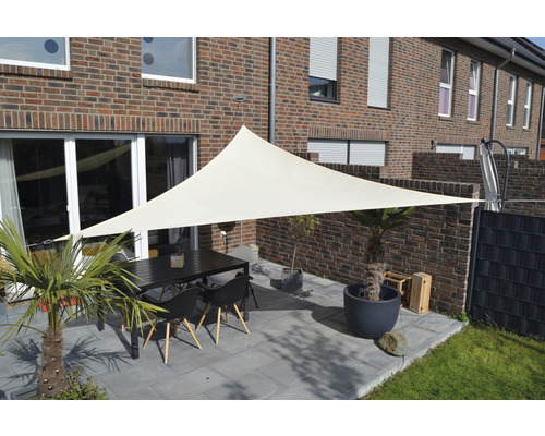 Terrasse mit Sonnensegel, Gartentisch und Stühlen vor einem Backsteinhaus