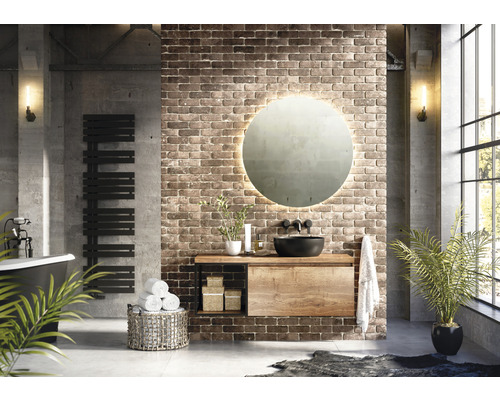 Modernes Badezimmer mit Waschtisch, Spiegel, Handtuchwärmer und Accessoires vor einer Backsteinwand
