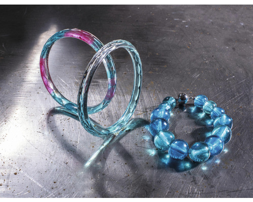 Zwei Armbänder aus Glas auf einer Metalloberfläche
