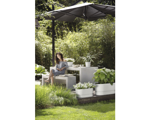 Jardin avec parasol, table, bancs et jardinières plantées