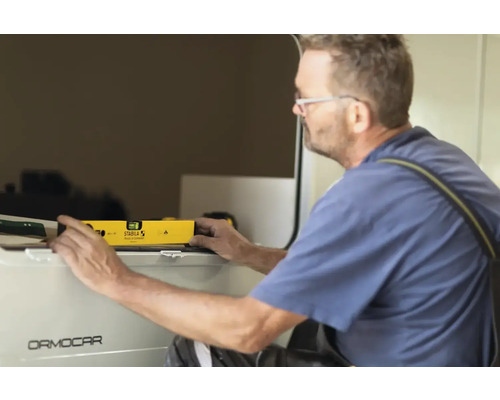 Handwerker benutzt Wasserwaage zum Ausrichten von Bauteilen