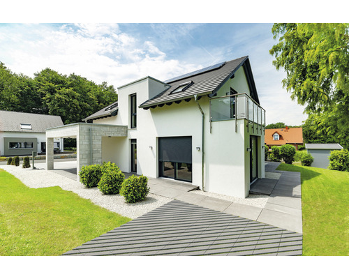 Modernes Haus mit Rollladen und gepflasterter Auffahrt