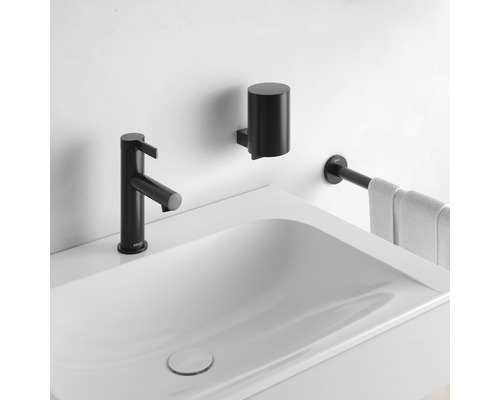 Waschbecken mit schwarzer Armatur, Seifenspender und Handtuchhalter