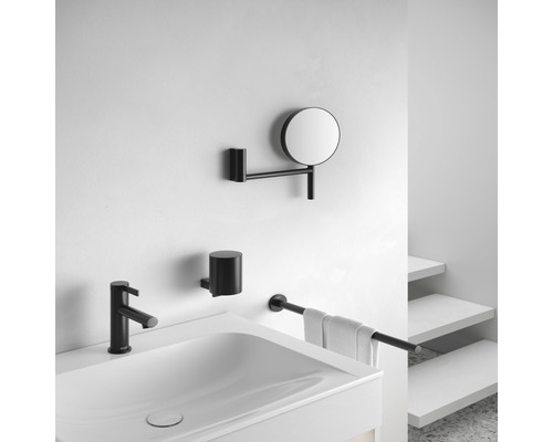 Badezimmer mit Waschbecken, Armatur, Kosmetikspiegel, Zahnputzbecher und Handtuchhalter