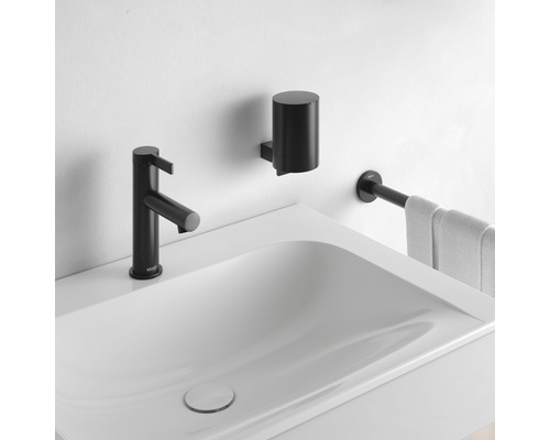 Waschbecken mit schwarzer Armatur, Seifenspender und Handtuchhalter