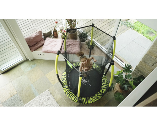 Enfant sur un trampoline de jardin avec filet de sécurité de la marque Exit Toys à l''intérieur.