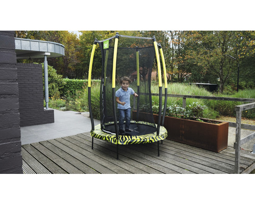 Enfant sautant sur un trampoline de jardin avec filet de sécurité
