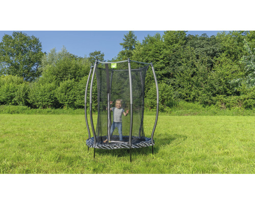Enfant sur un trampoline de jardin avec filet de sécurité