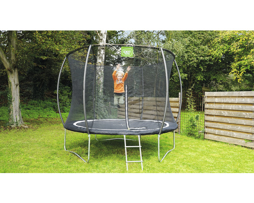 Kind springt auf einem Gartentrampolin mit Sicherheitsnetz und Leiter.