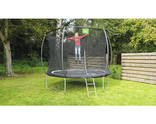 Rundes Gartentrampolin mit Sicherheitsnetz und Leiter im Garten mit springendem Kind