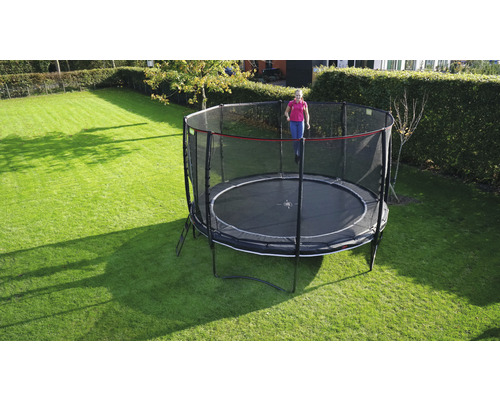 Trampoline de jardin rond avec filet de sécurité sur une pelouse