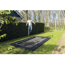 Ebenerdiges Gartentrampolin mit springendem Mann im Garten