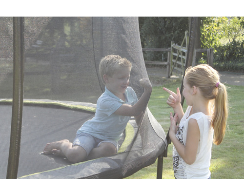 Zwei Kinder spielen auf einem Gartentrampolin mit Sicherheitsnetz.