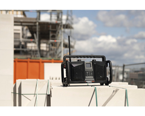 Radio de chantier sur maçonnerie avec échafaudage de chantier en arrière-plan