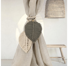 Dekorative Vorhanghalter mit Blattdesign, Seilbefestigung und geflochtener Lampe in einem hellen Raum.