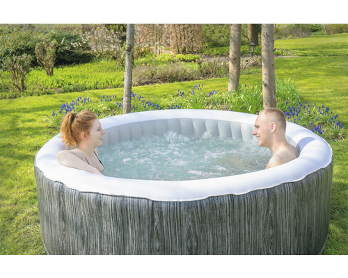 Jacuzzi gonflable avec deux personnes dans le jardin