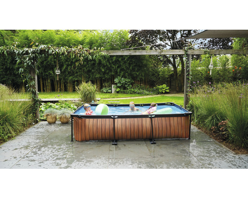 Piscine gonflable avec habillage en bois dans le jardin avec des enfants qui jouent
