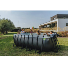 Une famille joue dans la piscine tubulaire EXIT Toys dans le jardin.