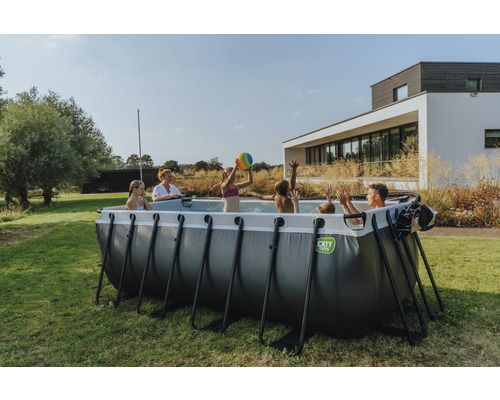 Une famille joue dans la piscine tubulaire EXIT Toys dans le jardin.