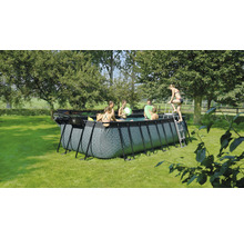 Piscine rectangulaire avec des personnes et une échelle dans le jardin