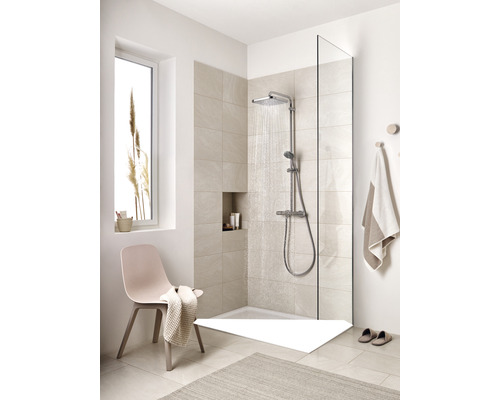 Salle de bains claire avec douche, robinetterie de douche, paroi de douche, chaise et tapis