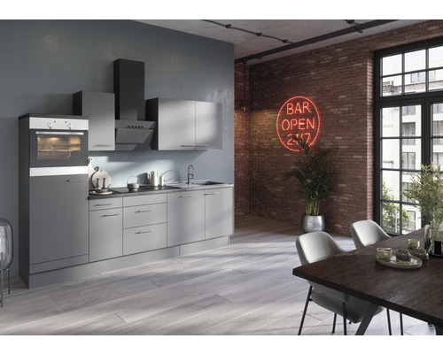 Cuisine moderne avec four intégré, hotte aspirante et armoires murales devant un mur de briques