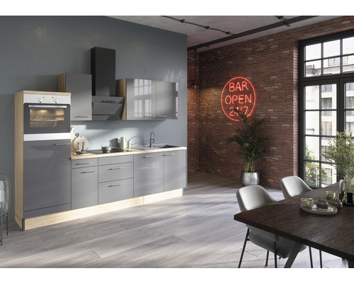 Cuisine moderne avec armoires grises, coin repas et enseigne lumineuse rouge sur le mur de briques.