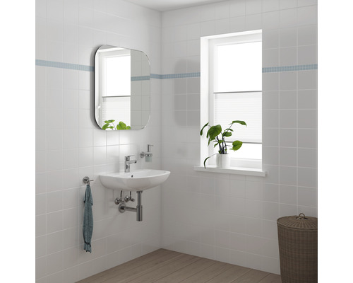 Salle de bain lumineuse avec miroir, lavabo, robinet, plante et panier