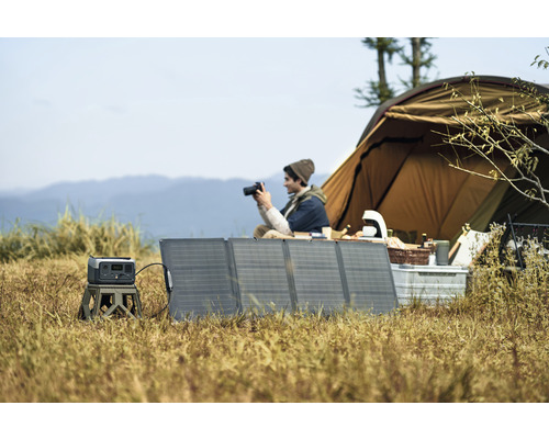 Campingplatz mit Zelt, Solarmodulen und Powerstation
