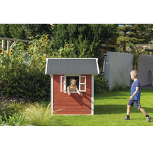 Enfant dans cabane de jeu en bois dans le jardin