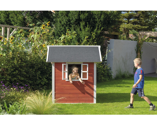 Kind im Spielhaus aus Holz im Garten