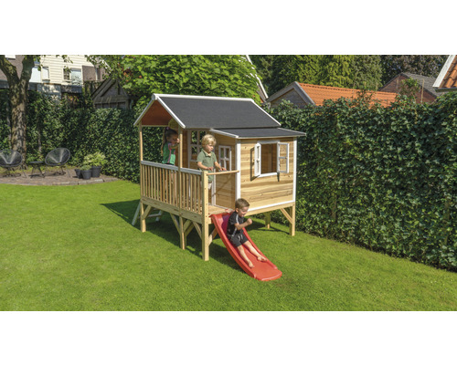 Maisonnette en bois avec toboggan dans le jardin avec des enfants qui jouent