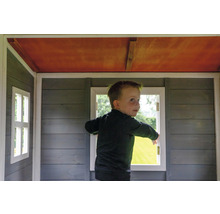 Kind im Spielhaus mit Holzfenstern und Holzwänden