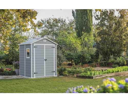 Gartenszene mit grauem Gerätehaus auf Rasenfläche