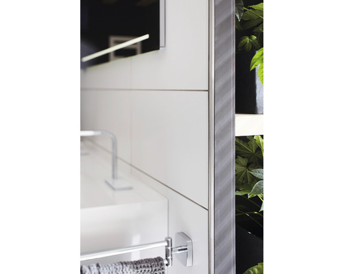 Detailansicht eines Badezimmers mit Waschbecken, Handtuchhalter, Spiegel und Pflanzen