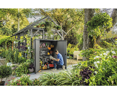 Scène avec une remise de jardin remplie d''outils et d''équipements de jardinage, entourée d''une végétation luxuriante