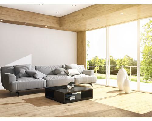 Salon lumineux avec canapé, table basse et baie vitrée