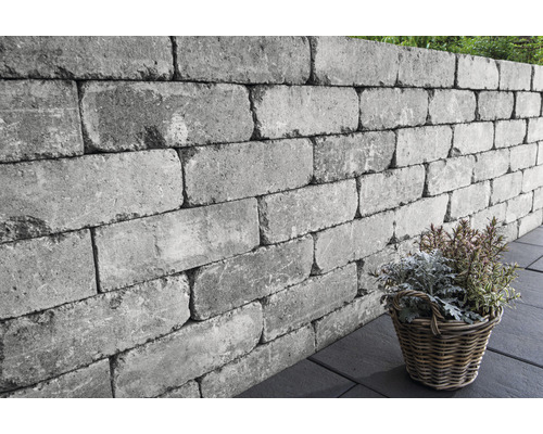 Muret de jardin gris en blocs de béton avec panier à plantes