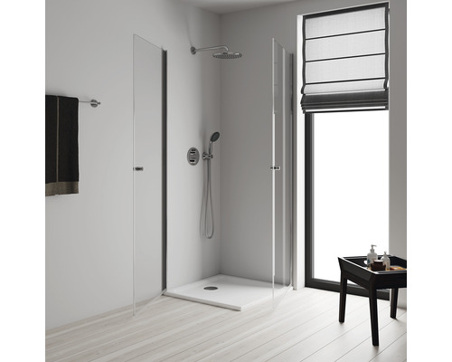 Salle de bains moderne avec douche en verre, pommeau de douche et serviette